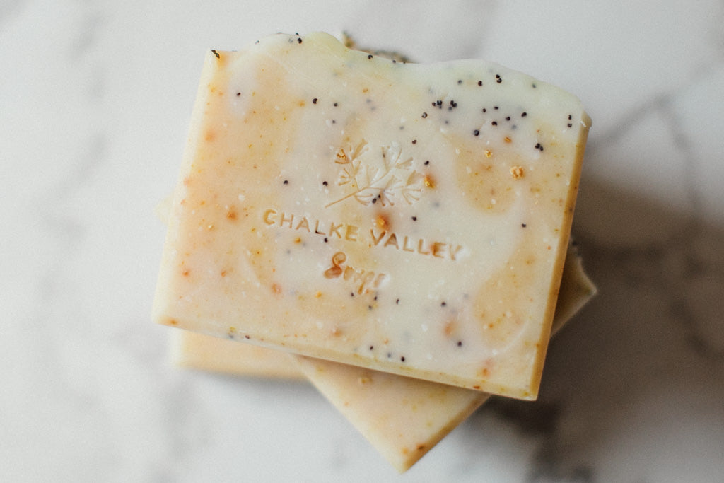 Citrus and poppy soap bars on a marble surface, branded 'Chalke Valley Soaps'.