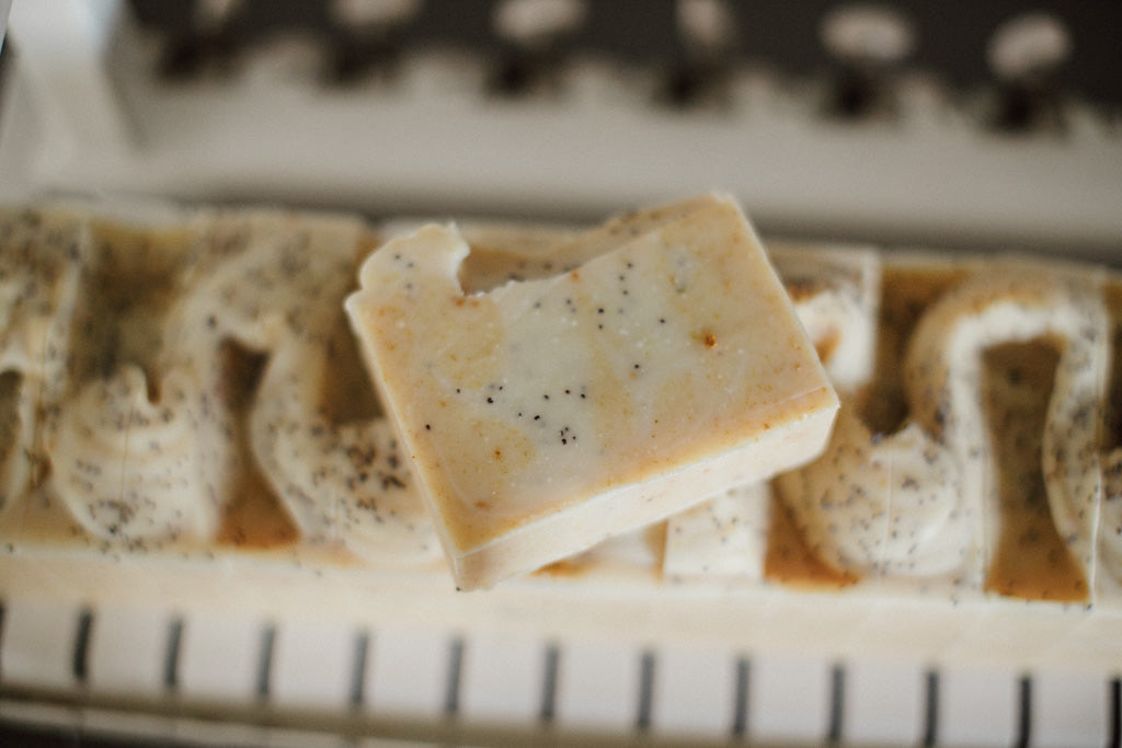 Bar of soap with specks on a sliced soap loaf