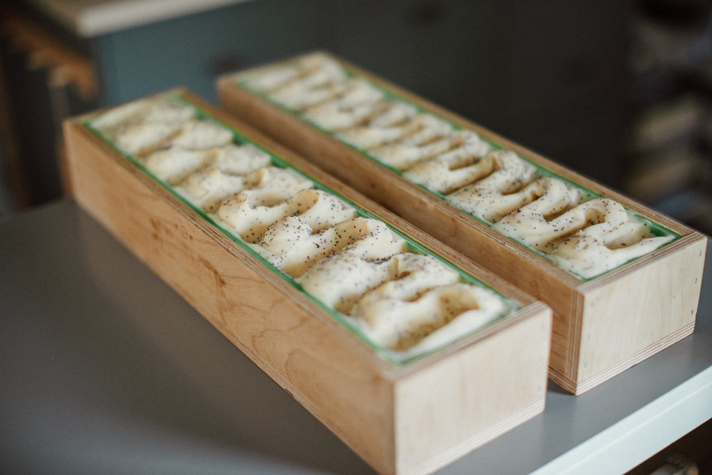 Two wooden soap moulds with citrus cold processed soap, ready for cutting